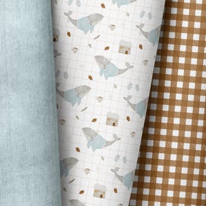 Pode incluir: Um fundo branco com um padrão repetido de baleias vestindo suéteres azuis, casas e xícaras de café. O padrão é cercado por um tecido jeans azul claro à esquerda e um tecido xadrez marrom e branco à direita.