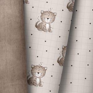 Könnte beinhalten: Ein nahtloses Muster mit beigefarbenem Hintergrund, einem Gitter aus schwarzen Herzen und einem sich wiederholenden Bild eines braunen und schwarz gefleckten Leoparden mit weißem Gesicht und schwarzen Augen.