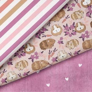 Könnte beinhalten: Drei Stoffmuster. Eines mit rosa und beigen Streifen, ein weiteres mit Meerschweinchen-Illustrationen, Karotten und Blumen auf hellrosa Hintergrund und ein drittes mit weißen Herzen auf rosa Hintergrund.