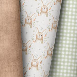 Può includere: Uno schema senza cuciture che presenta un design ripetitivo di conigli marroni con accenti bianchi, circondati da piccoli fiori blu e foglie verdi. Lo sfondo è di colore beige chiaro.