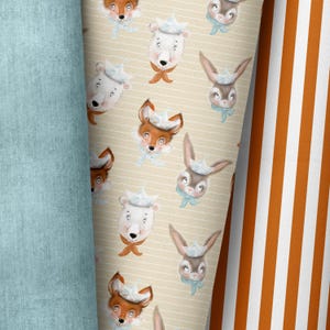 May include: A whimsical fabric design featuring repeating illustrations of foxes, polar bears, and rabbits, each wearing a paper boat hat and scarf. The background is a cream color with horizontal stripes. A light blue fabric and orange and white striped fabric are also visible.