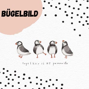 Può includere: Un'illustrazione di quattro pulcinella di mare con piume grigie, nere e bianche, ognuno con un becco colorato. Il testo "BÜGELBILD" è in alto e "Together is MY favourite" in basso. Punti neri sparsi.