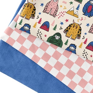 May include: Three fabric swatches stacked on top of each other. The top swatch features a white background with a repeating pattern of colourful monsters, stars, and mountains. The middle swatch is a pink and white checkered pattern. The bottom swatch is a solid blue colour.