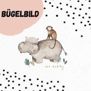 May include: A whimsical illustration featuring a hippo with a monkey riding on its back, accompanied by the text "HEY Buddy". The image is decorated with black polka dots and the German text "BÜGELBILD" on a pink background.