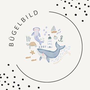 May include: A white iron-on transfer featuring a nautical theme with a blue whale, a hammerhead shark, a sea turtle, a lighthouse, a sailboat, and an anchor. The text BÜGELBILD and AHOY are printed in black. The design is framed by a thin black circle.