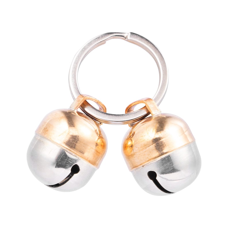 May include: Two silver bells with gold tops attached to a silver key ring.