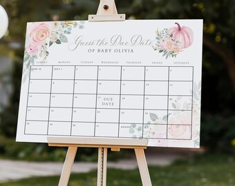 May include: A wooden easel displays a "Guess the Due Date of Baby Olivia" sign. The sign features a calendar grid with floral and pumpkin accents. White balloons and floral arrangements decorate the outdoor setting, creating a festive atmosphere for a baby shower.