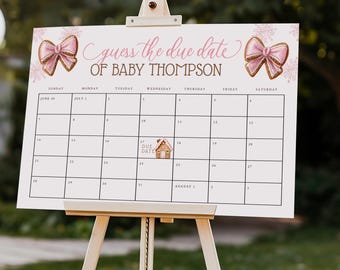 May include: A white calendar on a wooden easel with the text "Guess the due date of Baby Thompson." The calendar has a pink bow graphic and a small house graphic. The background is a blurred outdoor scene.