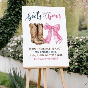 May include: A white sign on a wooden easel with the text "boots or bows" in blue and pink. The sign features illustrations of cowboy boots and a pink bow, with instructions for a baby gender reveal.