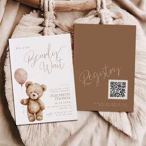 Puede incluir: Dos tarjetas con temática de baby shower. Una tarjeta tiene el texto "We Can Bearly Wait" con un osito de peluche sosteniendo un globo rosa. La otra tarjeta es marrón con el texto "Registry" y un código QR.