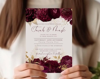 Könnte beinhalten: Hochzeitseinladung mit burgunderfarbenem Blumendesign und goldenen Akzenten. Der Text lautet "Tarah & Mark" und enthält das Datum "Samstag, 16. Oktober" und die Uhrzeit "Vier Uhr nachmittags".