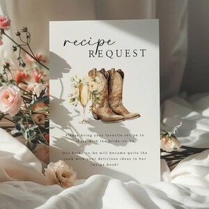 May include: A white card with the text "recipe request" in black calligraphy. The card features a watercolor illustration of a pair of brown cowboy boots with a glass of champagne and flowers.