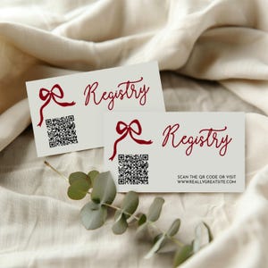 May include: Two white registry cards with red text and a bow graphic. Each card has a QR code and the word "Registry" in a script font. One card also includes the text "Scan the QR code or visit www.reallygreatsite.com".