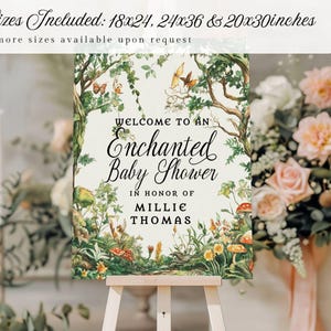 May include: A rectangular sign on a wooden easel featuring a forest illustration with mushrooms, butterflies, and greenery. The text reads: Welcome to an Enchanted Baby Shower in honor of Millie Thomas. Sizes included: 18x24, 24x36 & 20x30 inches.