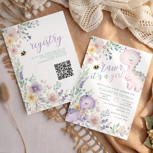 以下が含まれることがあります： 花と恐竜のイラストが描かれたベビーシャワーの招待状が2枚。1枚のカードにはQRコード付きで「registry」と書かれています。もう1枚にはイベントの詳細とともに「Rawr it's a girl」と書かれています。ソフトパステルカラーと蜂がデザインを強調しています。