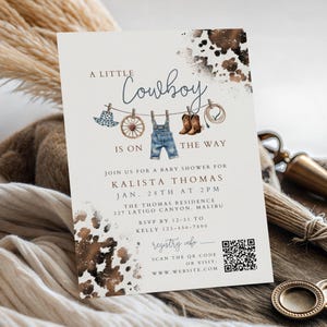 May include: A baby shower invitation card featuring a cowhide print border, a clothesline illustration with a hat, wagon wheel, denim overalls, boots, and a lasso, with text reading A LITTLE Cowboy IS ON THE WAY, event details, and a QR code.