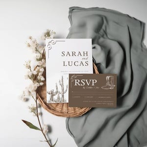 May include: A wedding invitation suite with a rustic theme. The main invitation features a white background with brown text that reads "Sarah and Lucas" and a drawing of cacti. The RSVP card is brown with white text and a drawing of cowboy boots.