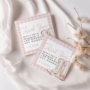 May include: Two pink and white gingham thank you cards with the text "Thank You! Millie's 1st Rodeo 1.13.2024" and a drawing of cowboy boots.