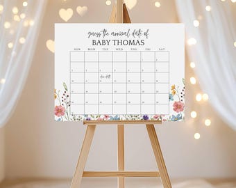 Può includere: Un calendario bianco su un cavalletto di legno con la scritta "guess the arrival date of BABY THOMAS". Il calendario ha un bordo floreale e una griglia per contrassegnare le date. Le parole "Due Date" sono scritte sul calendario.