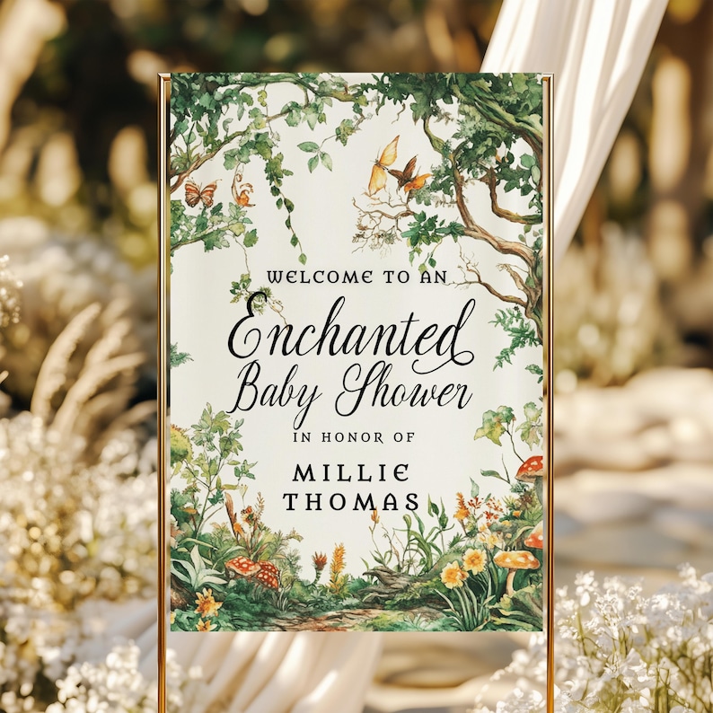 May include: A rectangular welcome sign for a baby shower featuring a cream background with a watercolor forest illustration of green trees, colorful butterflies, and mushrooms. The text reads: Welcome to an Enchanted Baby Shower in honor of Millie Thomas.