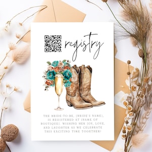 May include: A white card with the word "registry" written in black cursive script. A QR code is in the top left corner. A watercolor illustration of a bouquet of flowers, a champagne flute, and two brown cowboy boots is in the center. The text below the illustration reads "The bride-to-be, [bride's name], is registered at [name of boutique]. Wishing her joy, love, and laughter as we celebrate this exciting time together!"