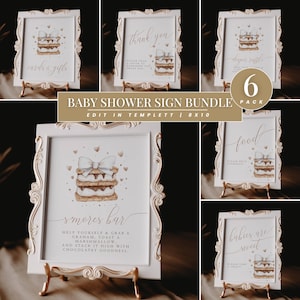 May include: A bundle of six baby shower signs in ornate white frames with gold stands. Each sign features a watercolor illustration of a s'more and text such as "cards & gifts", "thank you", "diaper raffle", "food", "s'mores bar", and "babies are sweet".