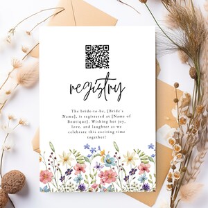 Può includere: Un biglietto bianco con un bordo floreale e un codice QR in bianco e nero. Il testo sul biglietto recita "registry" e "The bride-to-be, [Bride's Name], is registered at [Name of Boutique]. Wishing her joy, love, and laughter as we celebrate this exciting time together!"