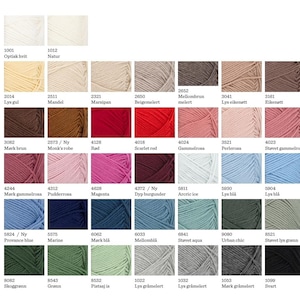 May include: A color chart displaying forty-two individual skeins of yarn arranged in a grid. Each square features a unique color, including various shades of white, beige, brown, red, pink, blue, green, gray, and black, with numerical codes.