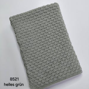May include: A rectangular light green knitted blanket featuring a consistent textured honeycomb stitch pattern throughout. The edges are finished with a simple border. The text 8521 helles gr&uuml;n is printed in black in the bottom left corner of the image.