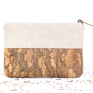 Puede incluir: Una peque&ntilde;a bolsa con cremallera con una parte superior de lino beige y una parte inferior de corcho. El corcho tiene un patr&oacute;n de m&aacute;rmol marr&oacute;n y negro natural.