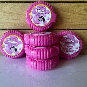 May include: Pink bubblegum containers with the text "Icky Sticky Bubblegum" and a cartoon girl blowing a bubble. One container has the text "Avery's 1st Birthday". The containers are stacked and arranged on a wooden surface.