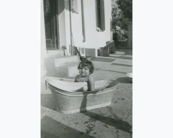 Summer time in the yard, small child near a metal bath tub. Greece 27.09. 1952.  Vintage photo. [52176]