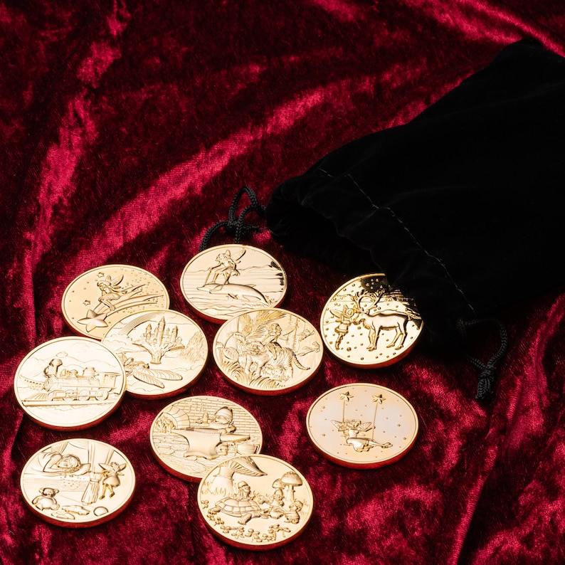 May include: A set of ten gold-colored metal tokens with various illustrations, including a train, a reindeer, a fairy, and a snowman. The tokens are arranged on a red velvet surface.