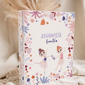 Könnte beinhalten: Ein weißer Ordner mit floralem Design und zwei Ballerina-Illustrationen. Der Ordner trägt die Aufschrift "Zeugnisse Emilia" auf der Vorderseite.
