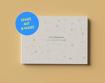 May include: A rectangular guest book with a light cream cover featuring a pattern of small gold and gray leaves. The center text reads ZUR ERINNERUNG an meine Taufe. A blue circular sticker in the top left corner displays the text SPARE MIT B-WARE.