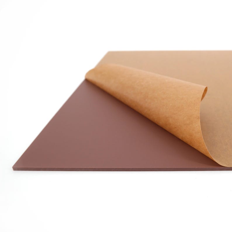 May include: A rectangular sheet of dark brown material with a protective brown paper layer partially peeled back, revealing the smooth surface. The sheet is set against a white background.