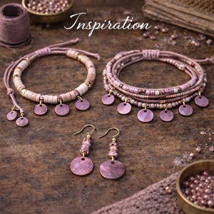 Op de afbeelding: Handgemaakte sieradenset met armbanden en oorbellen. De armbanden combineren kralen en ronde, roze schelpachtige bedels. De oorbellen hebben een vergelijkbaar ontwerp, met roze bedels en goudkleurige haken. Het woord "Inspiration" is cursief geschreven.