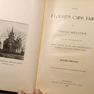 May include: Open book with the title "The Holden Cook Book of Tried Recipes." The cover features a black and white photo of a church. Text includes "Compiled and Issued by the Ladies' Church Aid" and "Revised Edition."