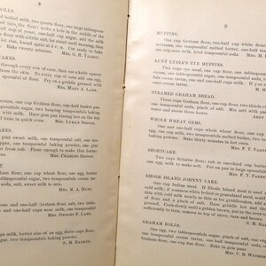 May include: Open book pages with handwritten recipes for various baked goods, including muffins, corn cakes, and rolls. The text is in black ink on aged paper, with some recipes attributed to specific individuals.