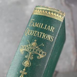 Könnte beinhalten: Ein grünes Buch mit goldenen Lettern, auf dem Rücken steht "Familiar Quotations" und "Bartlett".