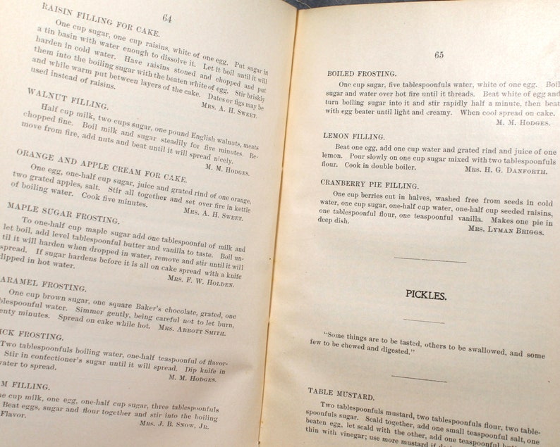 May include: A vintage cookbook page featuring recipes for cake fillings and frostings, including raisin, walnut, orange, and maple sugar variations. The page also includes a recipe for pickles and table mustard.