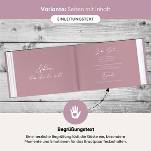 May include: A pink guest book with the text "Sch&ouml;n, lass ihr da seid!" on the left page and "Liebe G&auml;ste, Danke" on the right page. The book is open and lying flat on a wooden surface.