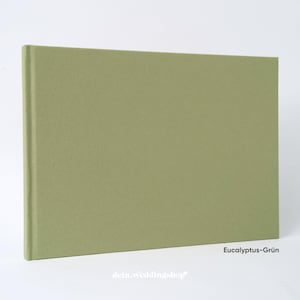 May include: A rectangular, sage green hardcover book. The book has a textured cover and a clean, minimalist design. The text "Eucalyptus-Gr&uuml;n" is visible in the lower right corner. The text "dein.weddingshop" is visible at the bottom.