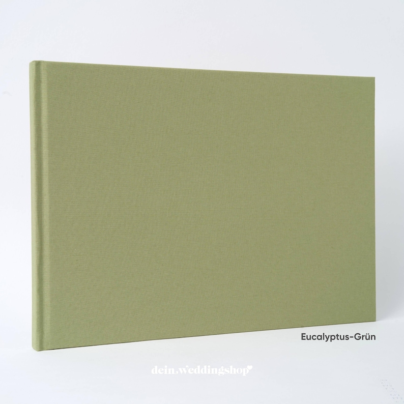 May include: A rectangular, sage green hardcover book. The book has a textured cover and a clean, minimalist design. The text "Eucalyptus-Gr&uuml;n" is visible in the lower right corner. The text "dein.weddingshop" is visible at the bottom.