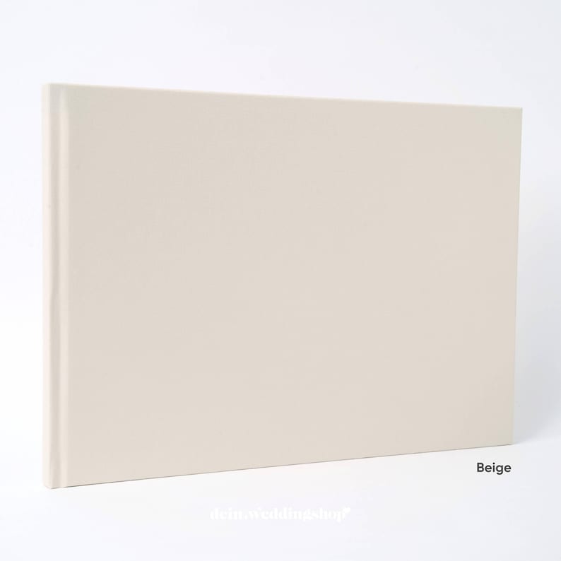 May include: A beige hardcover photo album. The album is rectangular with a smooth, solid cover. The spine is visible on the left side. The word "Beige" is printed in the bottom right corner. The album is on a white background.