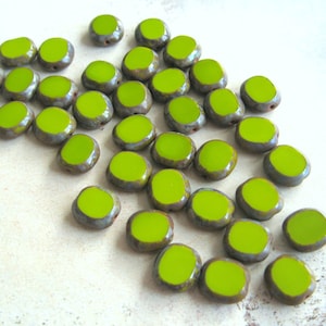 Könnte beinhalten: Eine Gruppe von lindgrünen Keramikperlen mit einer marmormusterartigen grauen Glasur. Die Perlen sind oval geformt und haben eine glatte, glänzende Oberfläche.