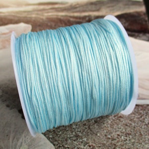 Puede incluir: Un carrete de cordón encerado azul claro, perfecto para la elaboración de joyas o manualidades.