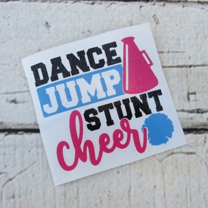 May include: A white sticker with the text "Dance Jump Stunt Cheer" in black, pink, and blue lettering. A pink megaphone and a blue pom-pom are included in the design.