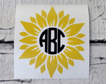 May include: A yellow sunflower decal with a black circle in the center. The circle has the letters "ABC" in white inside.