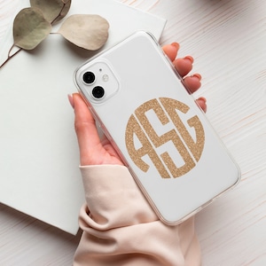 May include: A white phone case with a gold glitter monogram of the letters "A S G" in a circle.